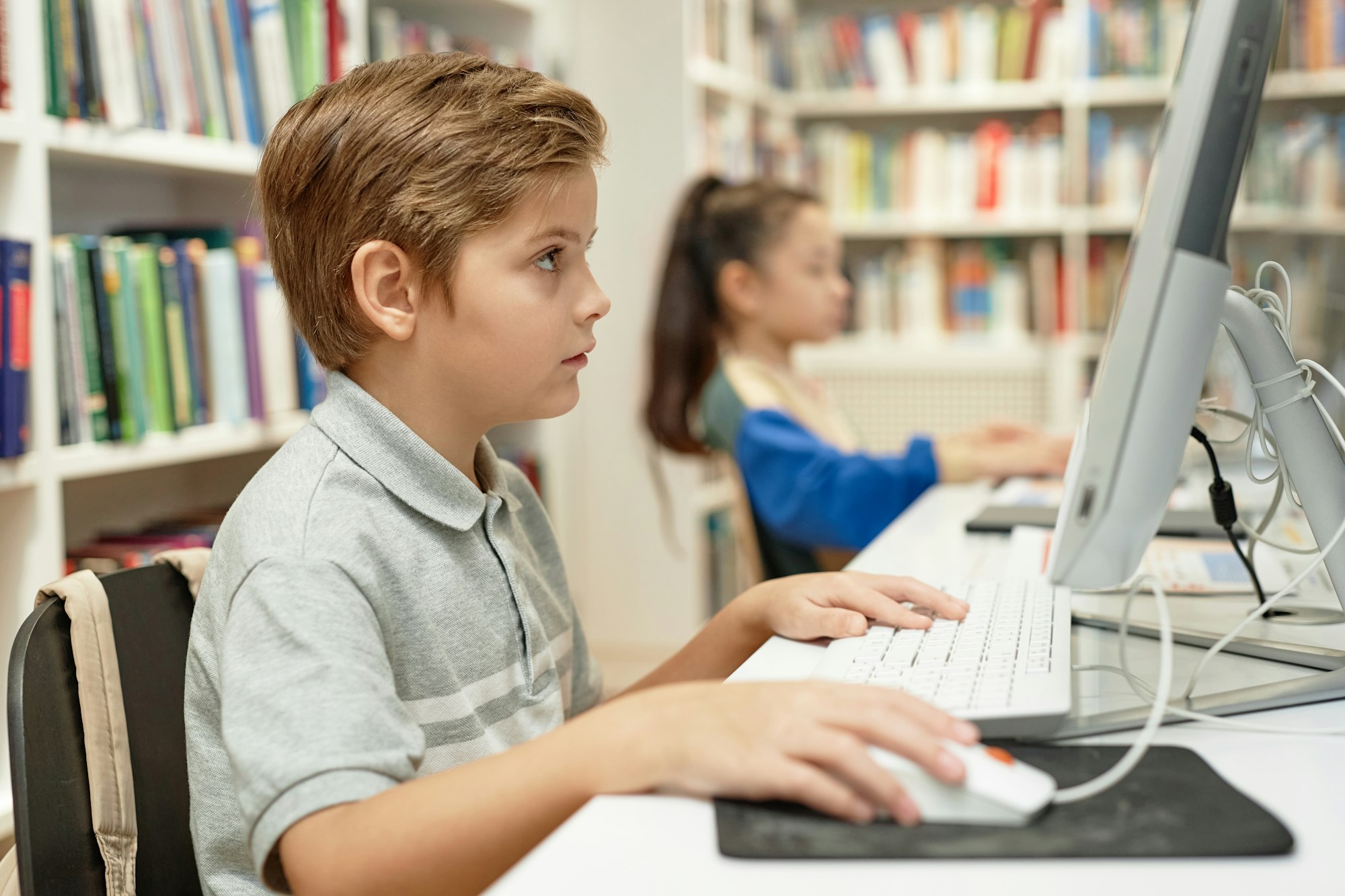 Poważny chłopiec korzystający z komputera na zajęciach z programowania dla dzieci